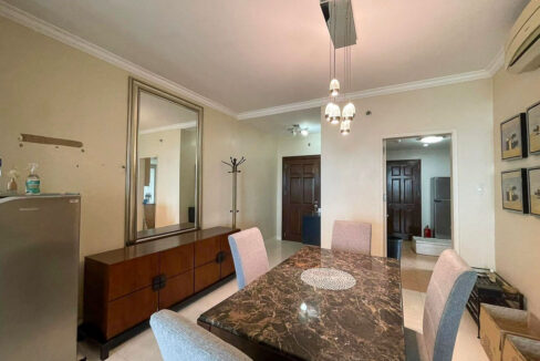Dining area by the entry with a wood sideboard and full-length mirror