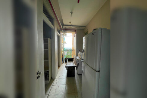 Service passage with a refrigerator and washer leading to the service balcony