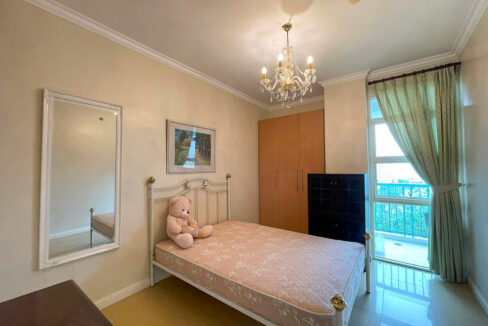 Master bedroom with a crystal chandelier, wardrobe and glass door to the balcony