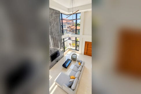 View from the mezzanine down to the living room and tall corner windows
