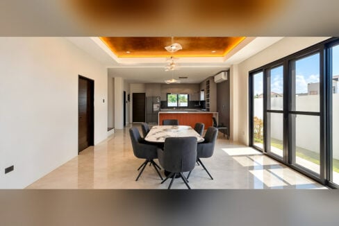 Dining area with marble-top table, cove-lit ceiling and sliding glass doors to the garden