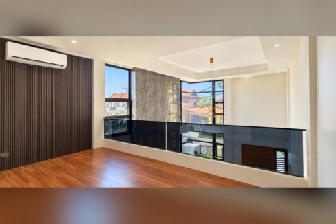 Upstairs family area with fluted wall panel overlooking the double-height living room