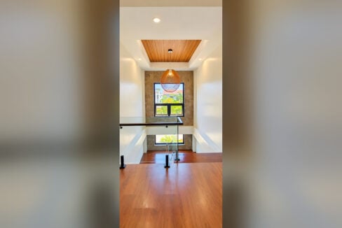 Stair landing with woven pendant light, wood-slat ceiling and marble-clad window