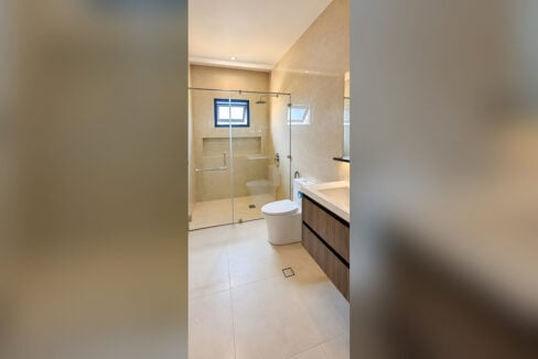 Bathroom with glass shower enclosure, rain shower, toilet and floating vanity