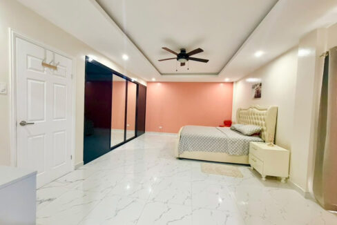 Master bedroom with a tray ceiling, ceiling fan and mirrored wardrobe