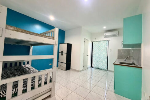 Studio-style room with a bunk bed and aqua kitchenette in this Cordova home
