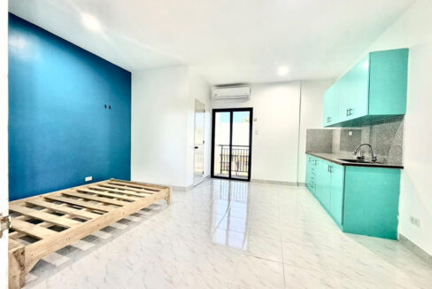 Studio room with a kitchenette and sliding glass door to the balcony
