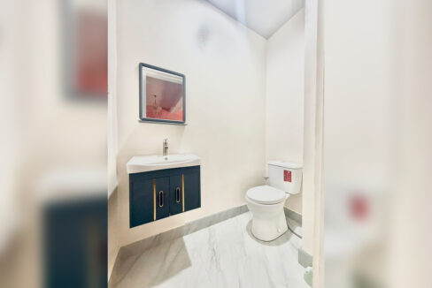 Powder room with a navy floating vanity and gold handles