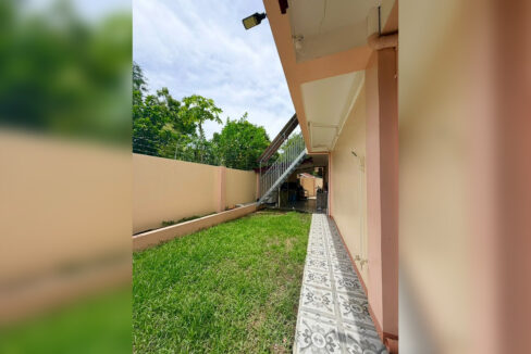 Side lawn and patterned-tile path along the Buagsong house in Cordova