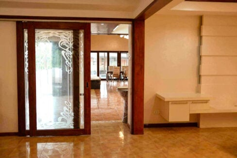 Wood-framed sliding door with etched glass opening from the hall to the dining area