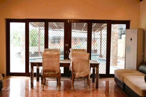 Dining area with full-height glass doors looking out to the pool