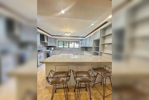 Granite kitchen island with three wire-frame bar stools