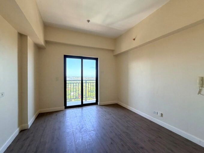 Brand-new studio for sale at Grand Residences, Cebu, with a glass door to the balcony
