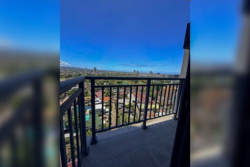 19th-floor balcony with a dark metal railing over the city and golf course