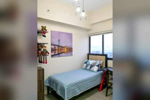 Second bedroom with a single bed, a study desk and cage pendant lights