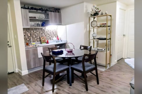 Dining nook with a round glass-top table for four beside the kitchenette