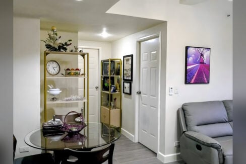 Dining area with gold-framed shelving and white panel doors