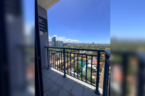 19th-floor balcony with a metal railing overlooking the city and hills