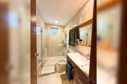 Bathroom with glass shower and wall shelf