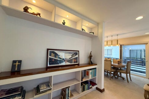 Built-in bookshelves with lit display niches, dining area beyond