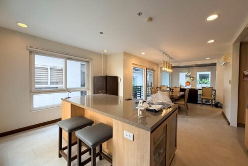 Quartz kitchen island and dining area with gold pendant lights