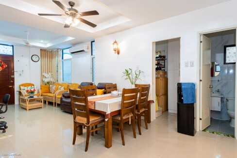 Wooden dining table for six beside the living area and a ground-floor bathroom