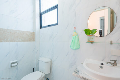 Bathroom with a round mirror, glass shelf and frosted window