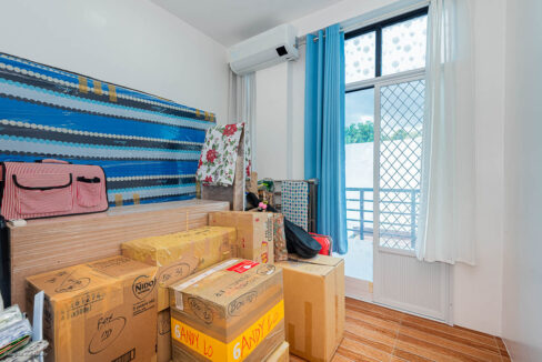 Bedroom with split-type aircon and a grilled glass door to the balcony
