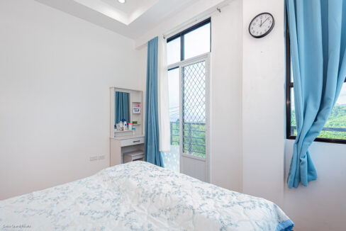 Bedroom dressing table beside the balcony door with views of green hills