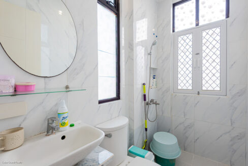 Bathroom with a wall-hung basin, glass shelf and walk-in shower