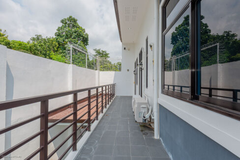 Side terrace with tiled floor and dark metal railing
