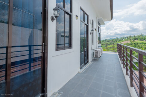 Long tiled terrace with sliding glass doors and a view of the hills