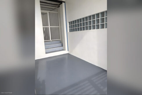 Enclosed garage with a painted grey floor and glass-block window