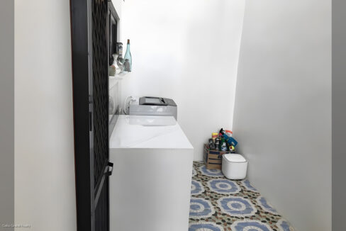 Laundry nook with a washer and patterned floor tiles