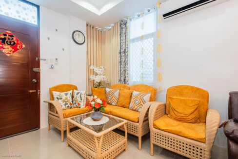 Rattan sofa set with mustard cushions and a glass-top coffee table