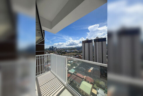 Corner balcony with glass railing overlooking the Mandaue skyline and nearby towers