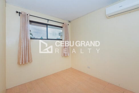 Second bedroom with window, curtains and split-type air conditioner
