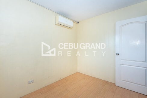 Empty second bedroom with wood-look floor and white panel door