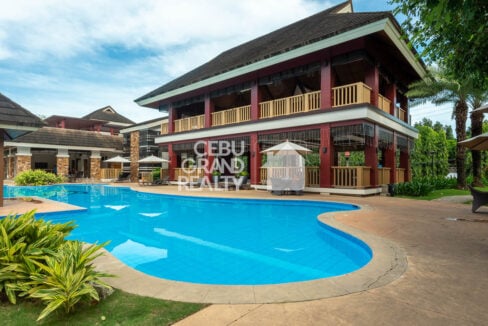 Curved swimming pool in front of the two-storey One Oasis pavilion