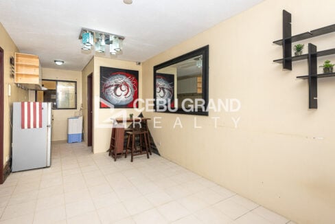 Open living and dining space with a large framed mirror and floating wall shelves