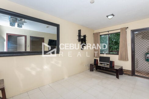 Living room corner with curtained window, media console and wall mirror