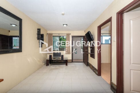 Long view of the tiled living area toward the window and main door
