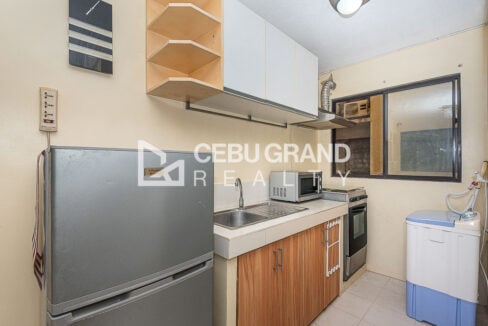 Kitchen with two-door refrigerator, stainless sink, microwave, range and washing machine