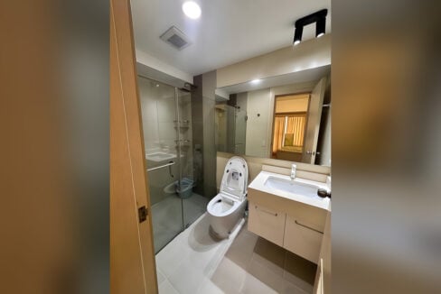 Bathroom with a glass shower enclosure, smart toilet and wide vanity mirror