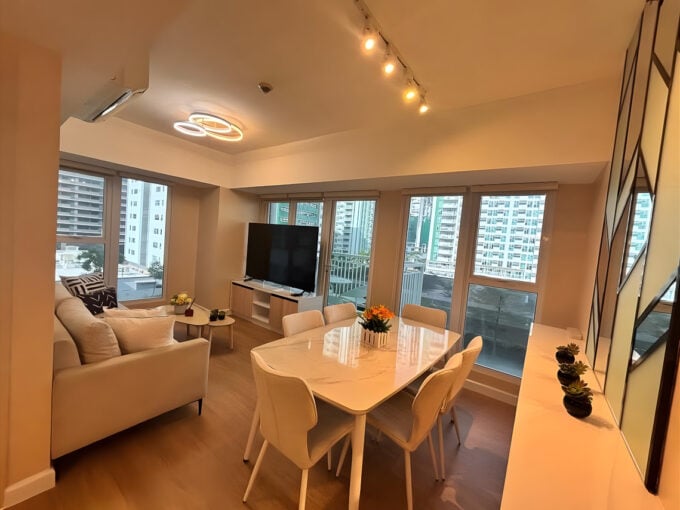 Living and dining area with windows on two sides and city views at Solinea, Cebu Business Park