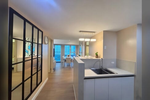 Kitchen peninsula with a double stainless sink and pendant lights, looking through to the dining area