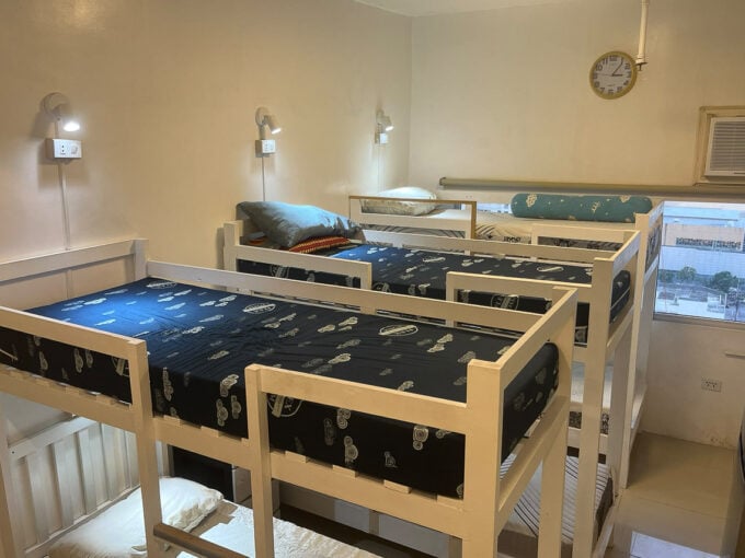 Renovated studio for sale at San Marino Residences, set up with white bunk beds and wall reading lamps