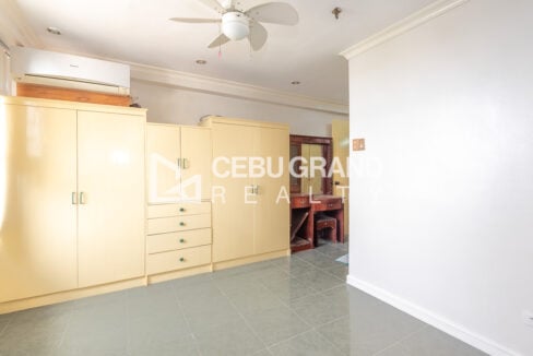 Built-in wardrobes and drawers with a split-type air conditioner in the master bedroom