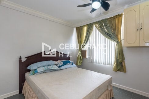 Second bedroom with a bed, curtains and vertical blinds at Trinity Plaza, Gorordo Avenue