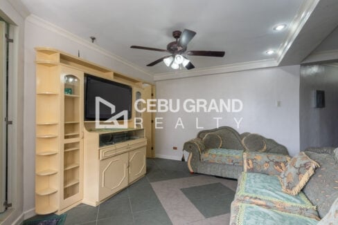 Built-in entertainment cabinet with a flat-screen TV and corner shelves